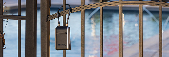 A cable lock on a gate leading to a swimming pool