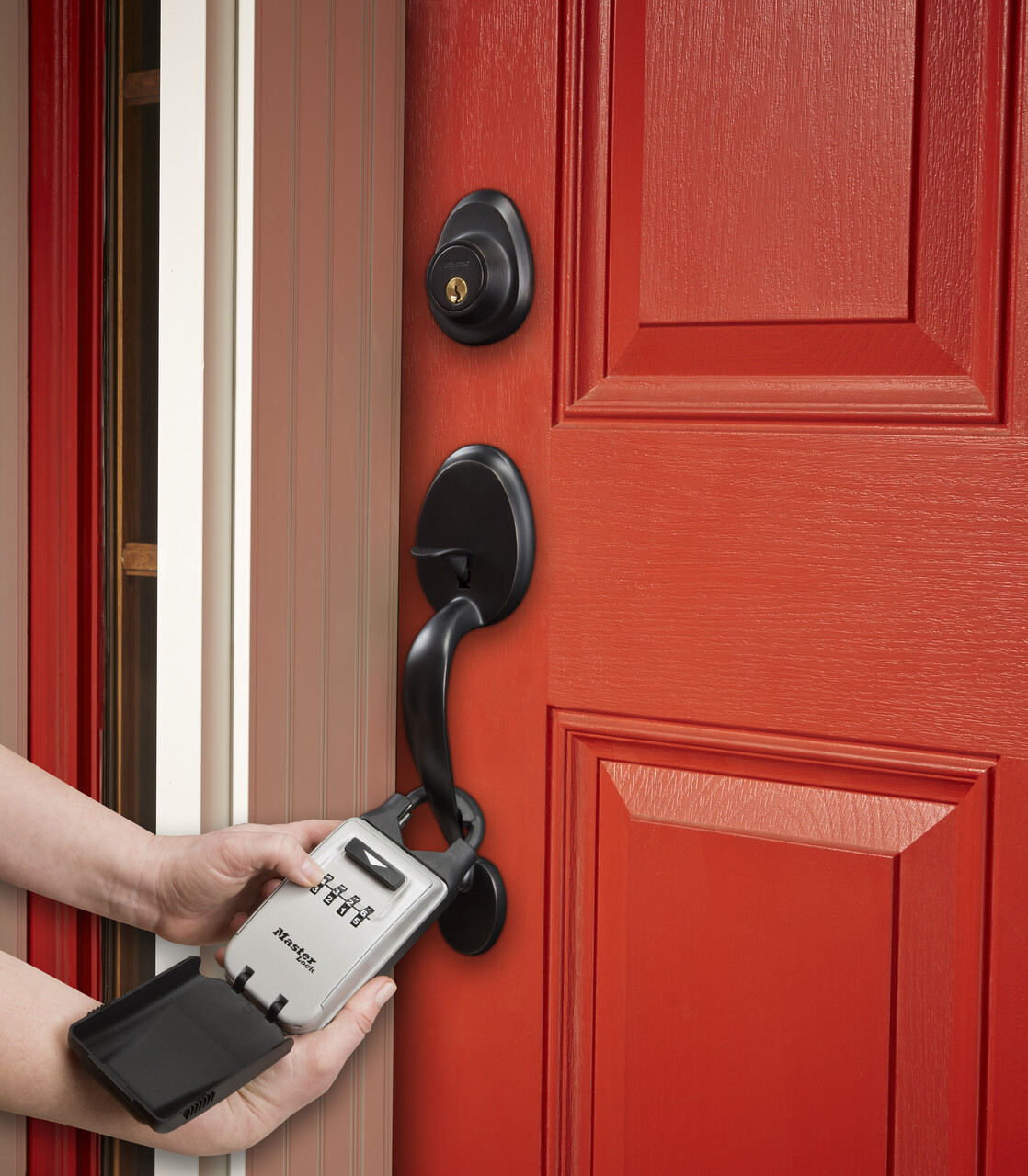 A lockbox being used, that is attached to the front door of a home.