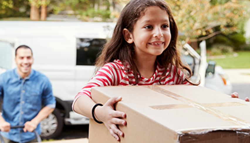 family unloading boxes from moving van