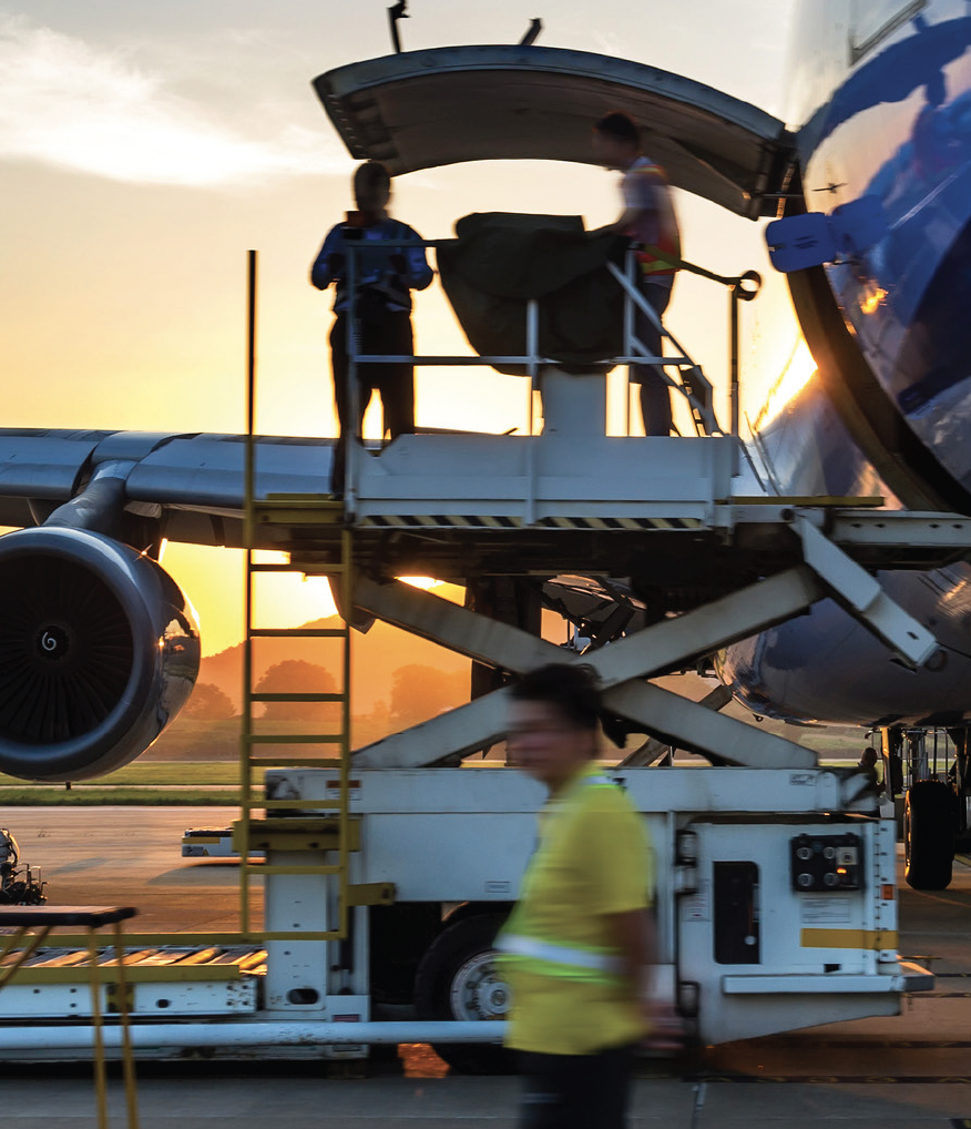 Southwest action photo - loading a plane with a sunset in the background